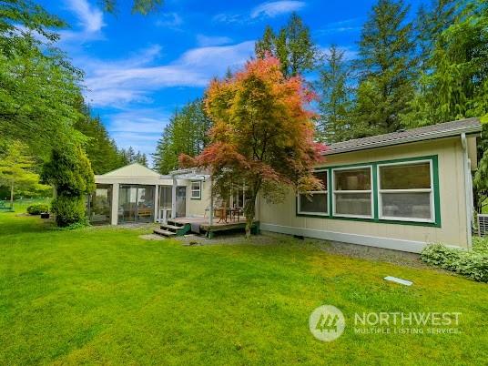 back of house featuring a deck and a lawn