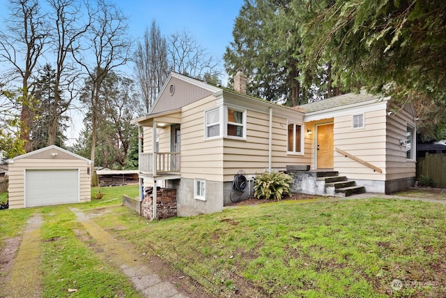 view of front of home featuring a garage, an outdoor structure, and a front lawn