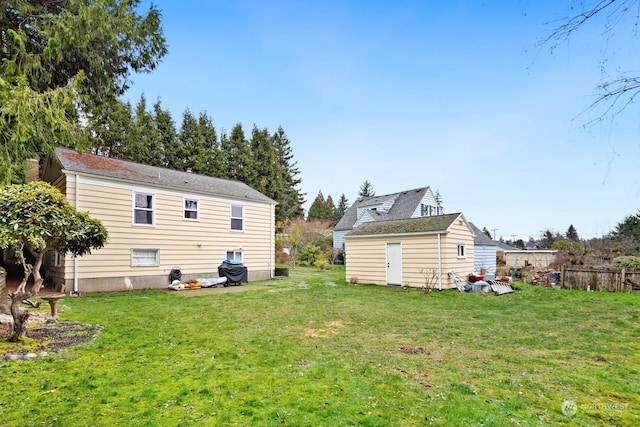 rear view of house with a yard and a shed