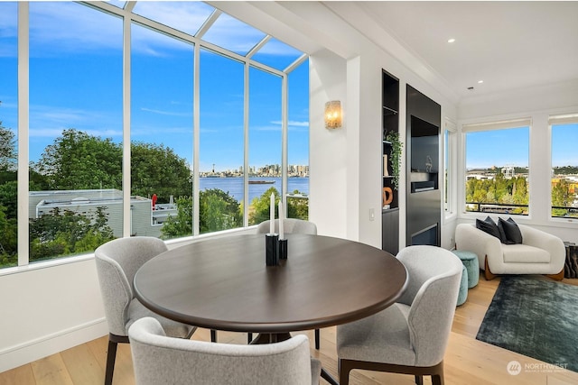 sunroom featuring a water view