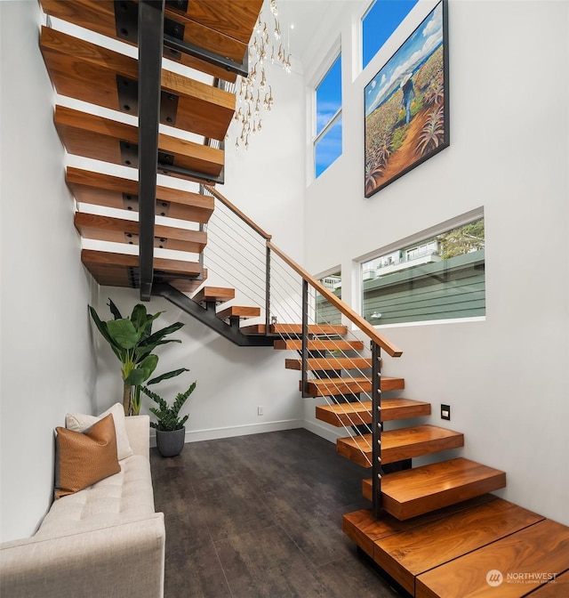 stairway featuring a high ceiling and hardwood / wood-style floors