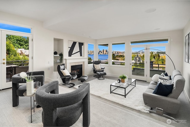 living room featuring light colored carpet and a water view