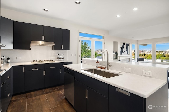 kitchen with stainless steel appliances, french doors, sink, backsplash, and a kitchen island with sink