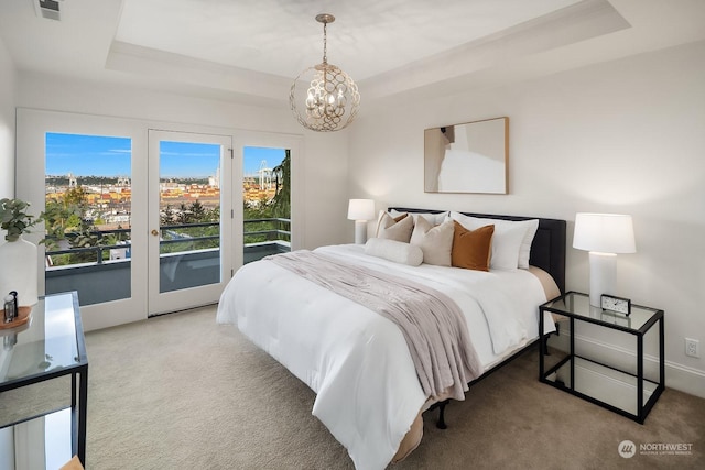 bedroom with access to outside, a chandelier, carpet flooring, and a raised ceiling