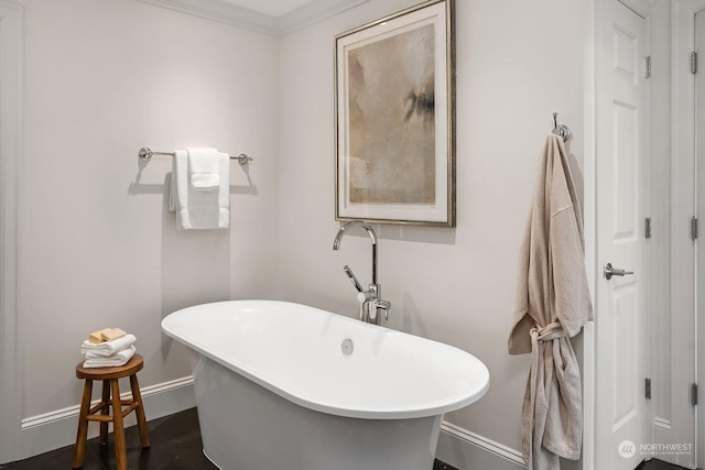 bathroom with a tub and ornamental molding