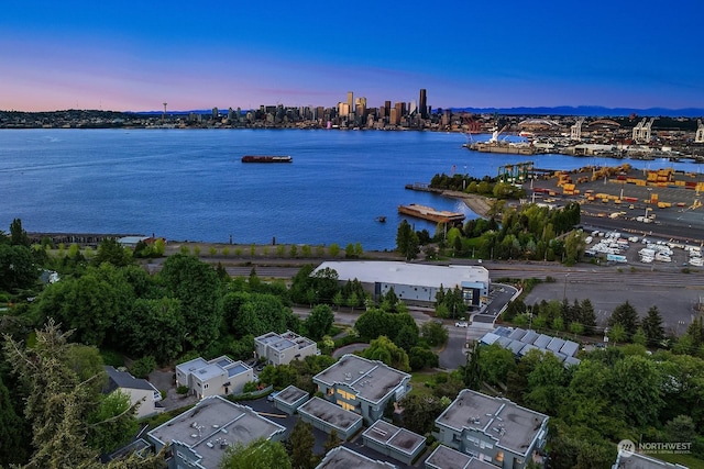 aerial view at dusk featuring a water view