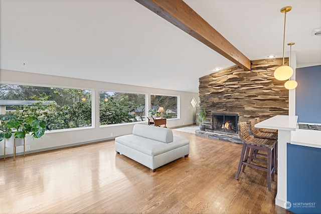 living room featuring a fireplace, wood-type flooring, and lofted ceiling with beams