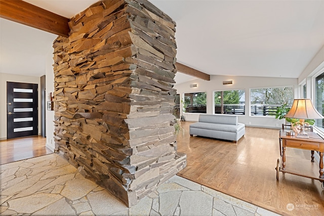 entrance foyer featuring wood-type flooring and lofted ceiling with beams