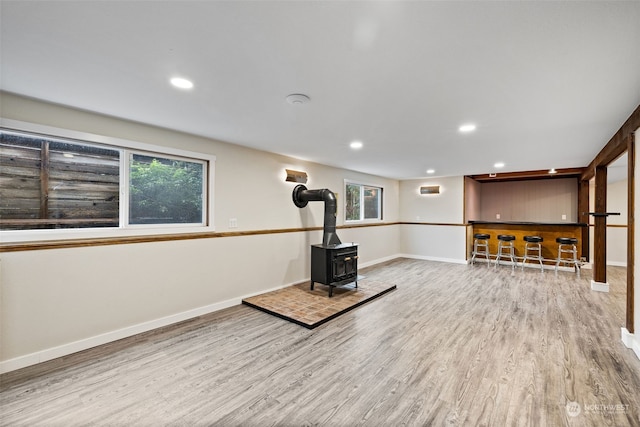 exercise room with light wood-type flooring and a wood stove