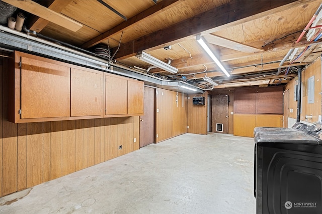 basement with wood walls and washing machine and clothes dryer