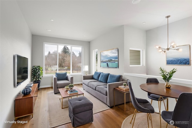 living room featuring light hardwood / wood-style floors and an inviting chandelier