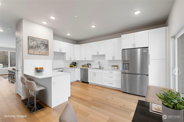 kitchen featuring light hardwood / wood-style floors, sink, white cabinets, and stainless steel appliances