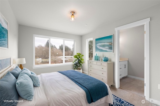 bedroom with light carpet and ensuite bath