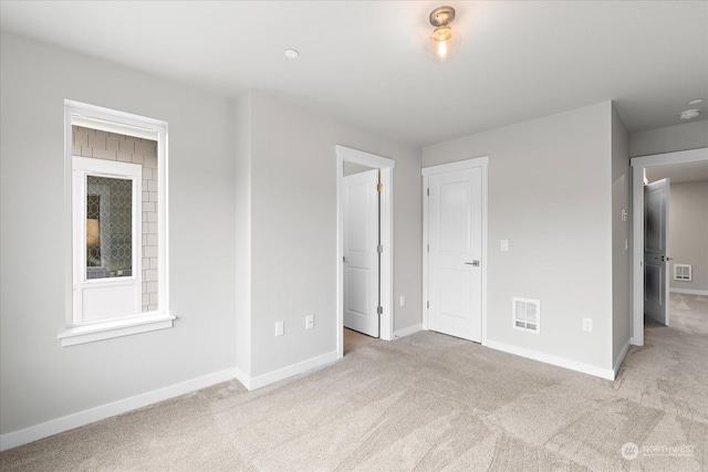 unfurnished bedroom featuring light carpet