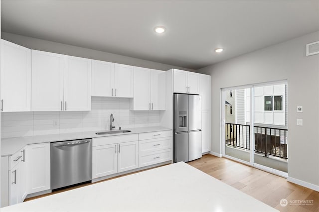 kitchen featuring light hardwood / wood-style floors, sink, white cabinetry, and stainless steel appliances