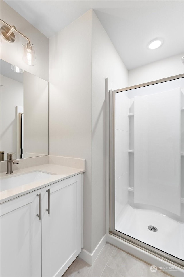 bathroom with an enclosed shower, vanity, and tile patterned floors