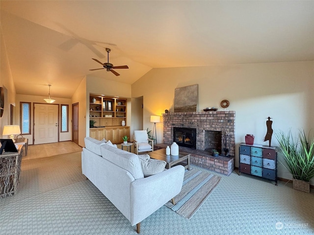 carpeted living room featuring a fireplace, vaulted ceiling, and ceiling fan