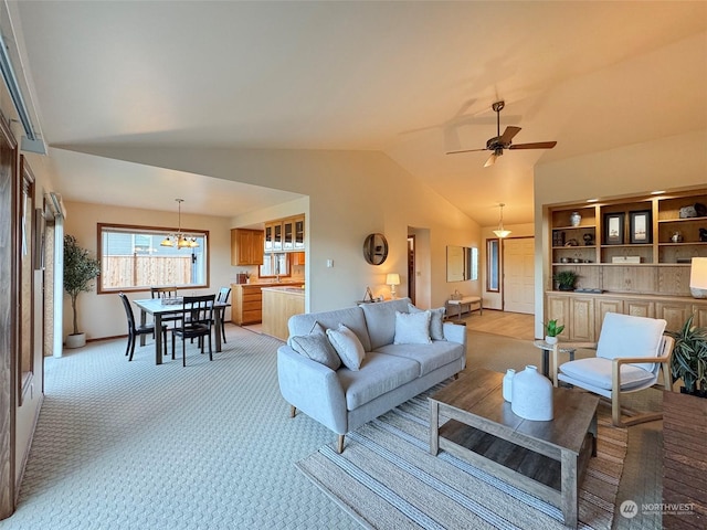 carpeted living room featuring ceiling fan with notable chandelier and vaulted ceiling