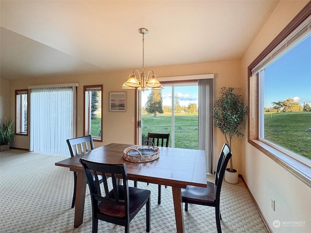 carpeted dining area featuring a chandelier