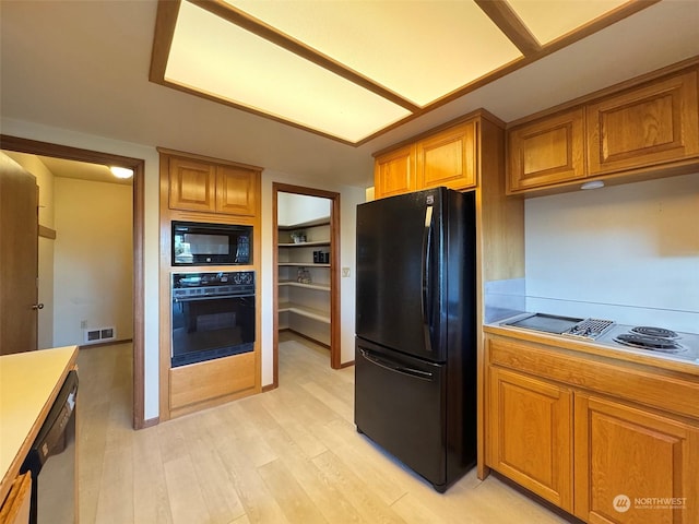 kitchen featuring light hardwood / wood-style flooring and black appliances