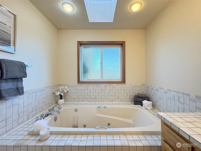 bathroom with vanity and tiled tub