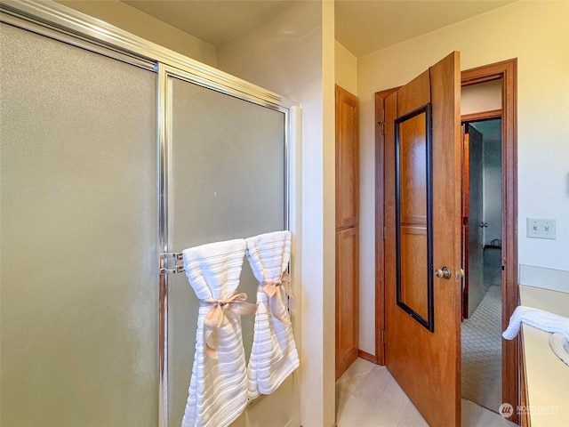 bathroom featuring vanity, a shower with shower door, and tile patterned floors