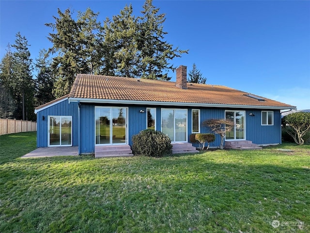 rear view of house with a patio and a lawn