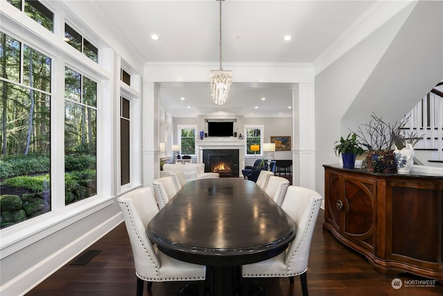 dining room with a chandelier, crown molding, and dark hardwood / wood-style floors