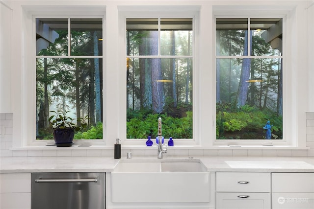 kitchen featuring white cabinets, dishwasher, tasteful backsplash, and sink