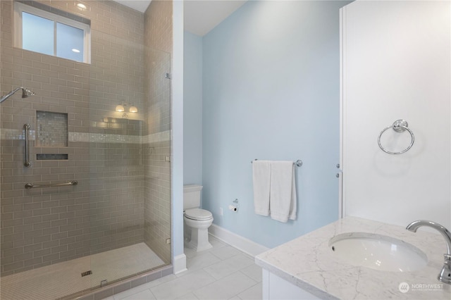 bathroom featuring toilet, a shower with door, vanity, and tile patterned floors