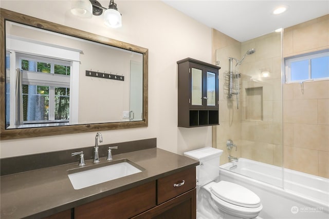 full bathroom featuring toilet, vanity, and tiled shower / bath