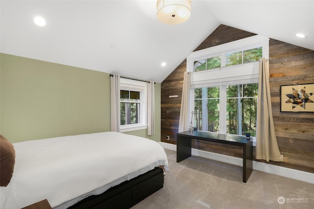 bedroom featuring wooden walls, vaulted ceiling, and light colored carpet