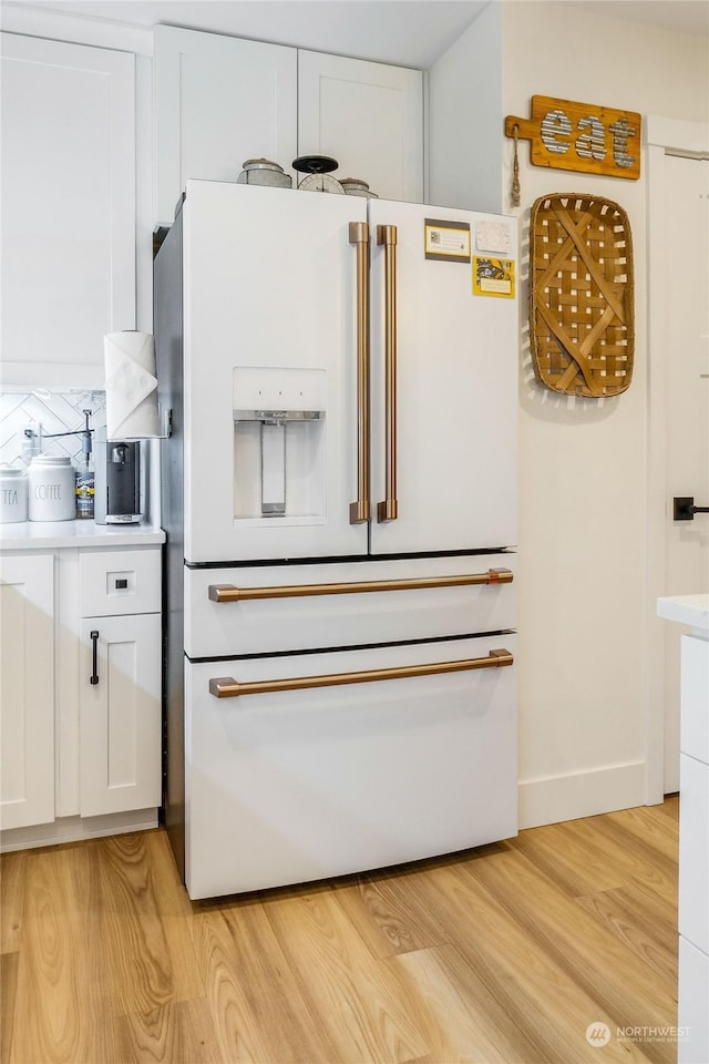 interior space featuring white cabinetry, high end fridge, and light hardwood / wood-style flooring