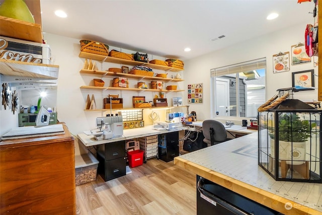 office with built in desk and light hardwood / wood-style flooring