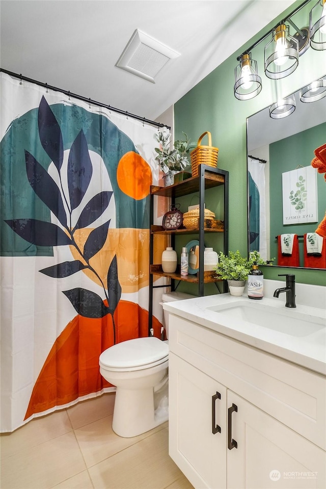 bathroom with tile patterned flooring, vanity, and toilet