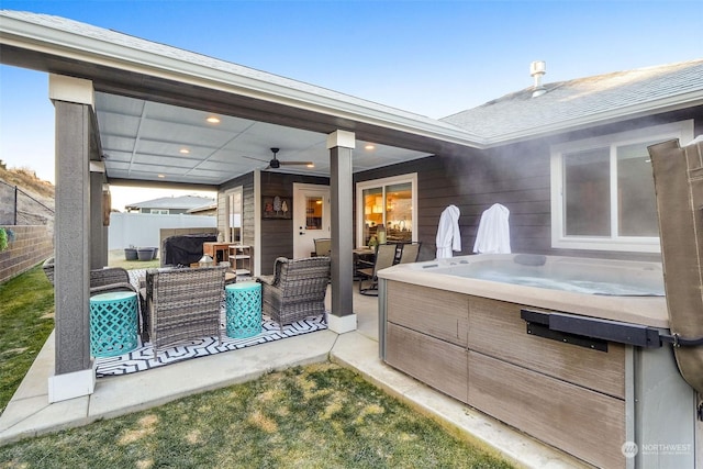 view of patio with a hot tub, outdoor lounge area, and ceiling fan