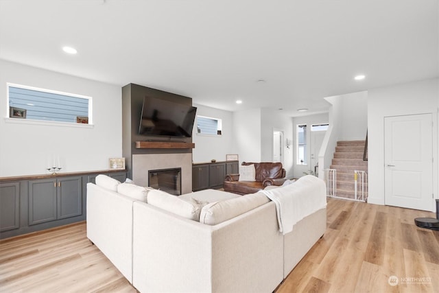 living room with a fireplace and light wood-type flooring