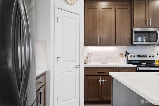 kitchen with appliances with stainless steel finishes, backsplash, and dark brown cabinetry