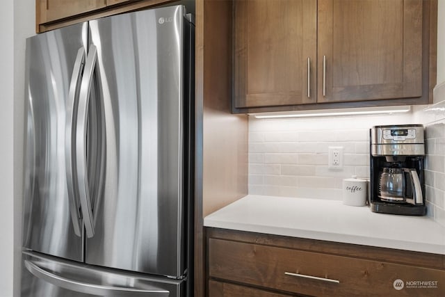 kitchen with decorative backsplash and stainless steel fridge