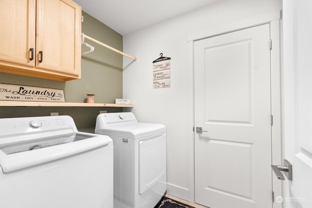 laundry room featuring washing machine and dryer and cabinets