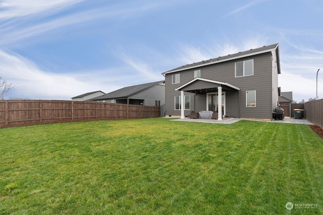 rear view of property featuring a yard and a patio area