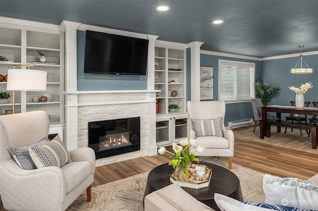 living room with crown molding, a fireplace, hardwood / wood-style flooring, and a baseboard radiator