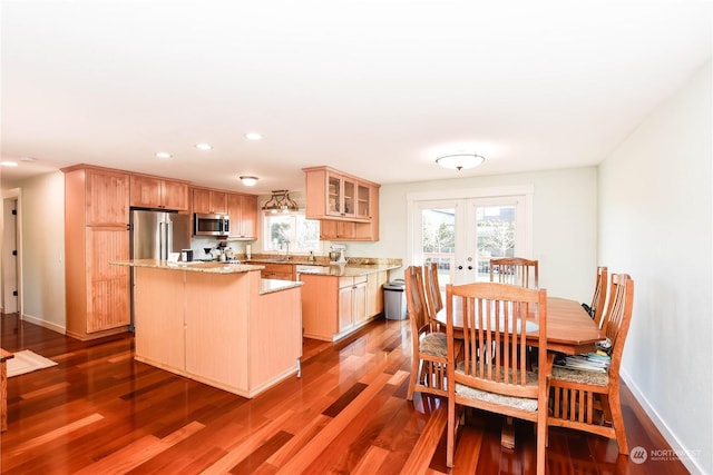 kitchen with a kitchen island, dark hardwood / wood-style flooring, french doors, and appliances with stainless steel finishes