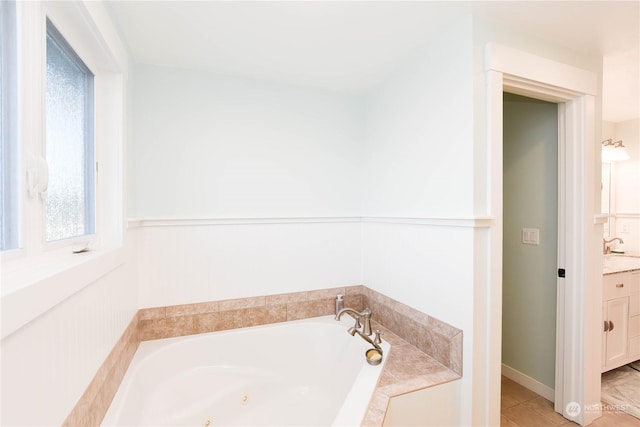 bathroom with tiled tub and vanity