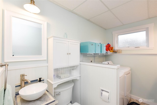 bathroom with toilet, vanity, and a drop ceiling