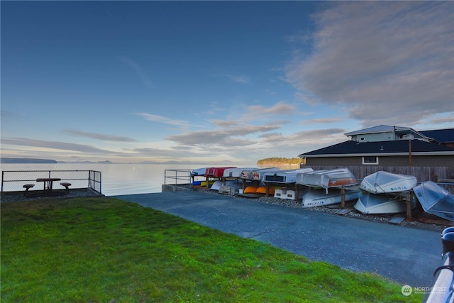 dock area with a yard and a water view