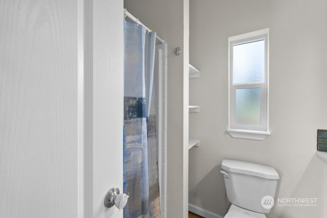 bathroom featuring walk in shower and toilet