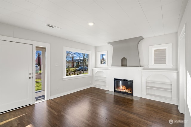 unfurnished living room with dark wood-type flooring and built in features