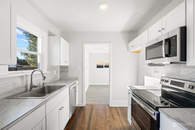 kitchen featuring sink, white cabinets, decorative backsplash, and appliances with stainless steel finishes