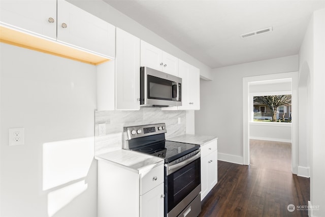 kitchen featuring stainless steel appliances, white cabinetry, backsplash, and dark hardwood / wood-style floors